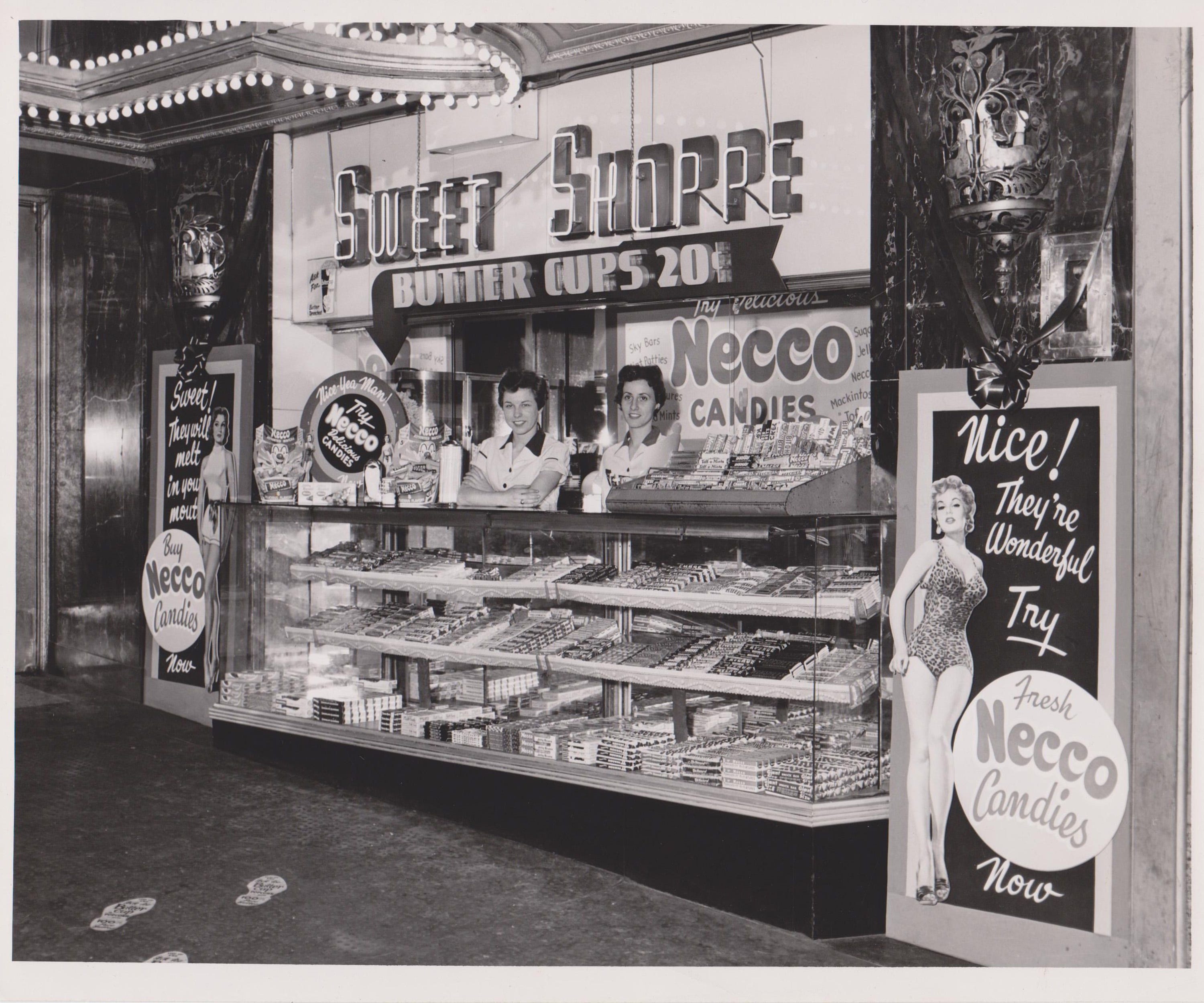 Vintage movie theater concession stand with glass candy cases and classic treats
